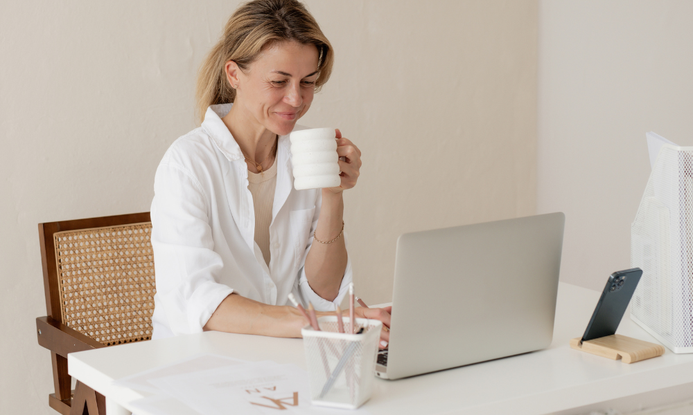 Female coach looking at a lapttop and smiling.